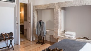 Une salle de bain moderne avec un mur en pierre, une baignoire et un espace douche.