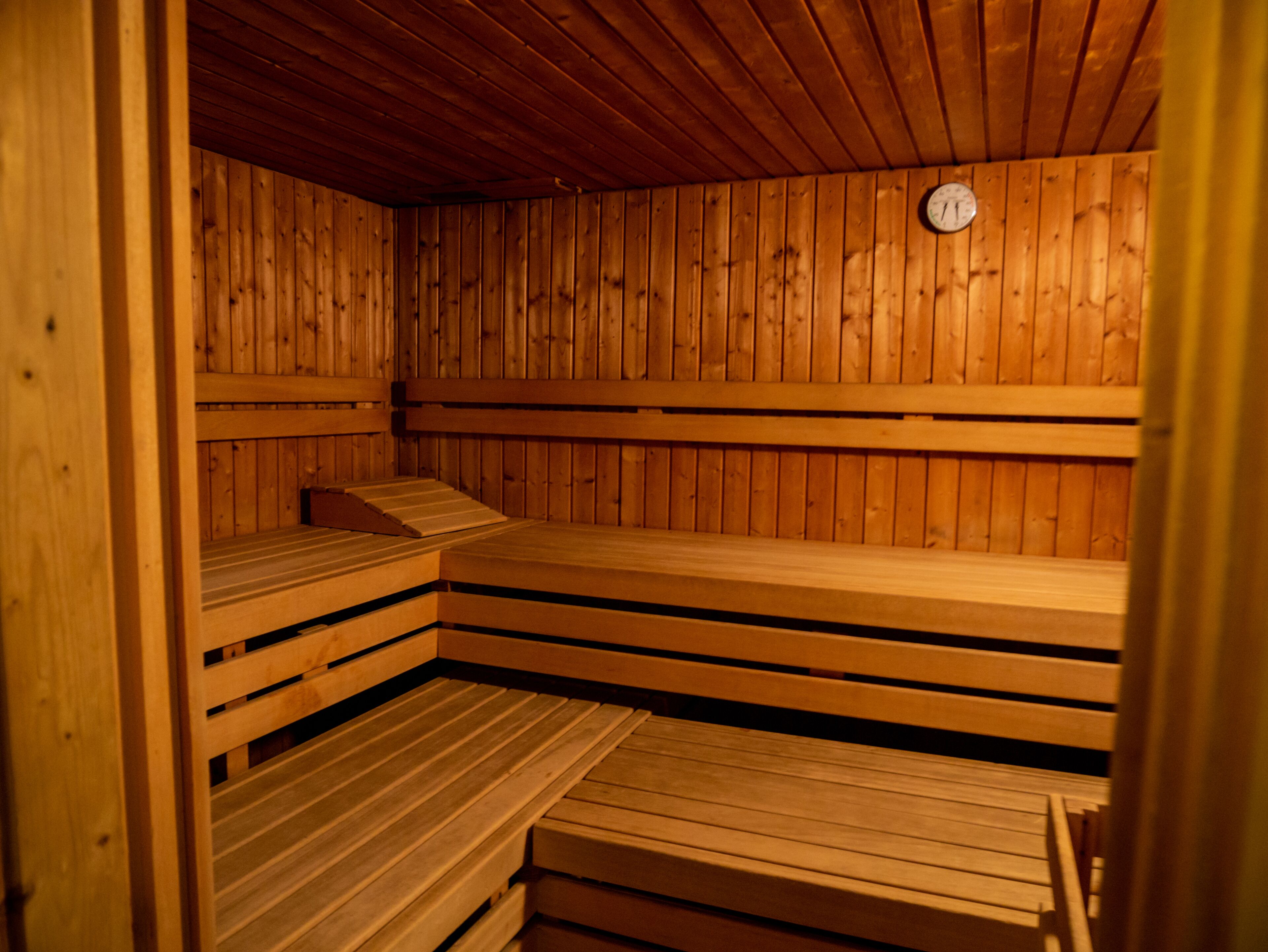 Un sauna avec des bancs en bois et une horloge au mur.