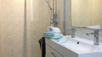 Chuveiro, secador de cabelo, shampoo, papel higiênico