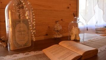 Una mesa de madera con un libro, una botella y un frasco de vidrio.