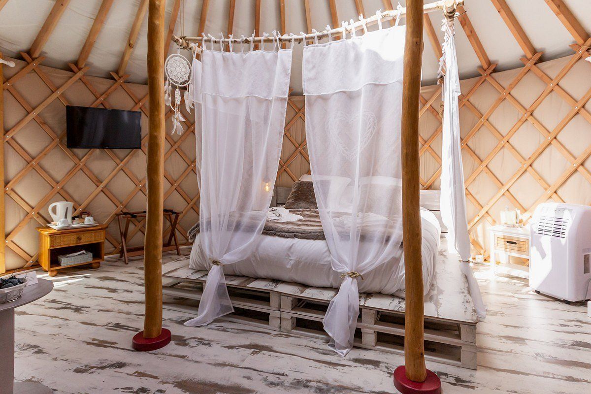 Ein gemütliches Zimmer mit einem Bett, einem Fernseher und einer Heizung.