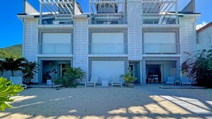 A modern two-story building with a covered outdoor seating area and a garage. - Grand Case Bleu Marine Sea Side (Grand-Case)