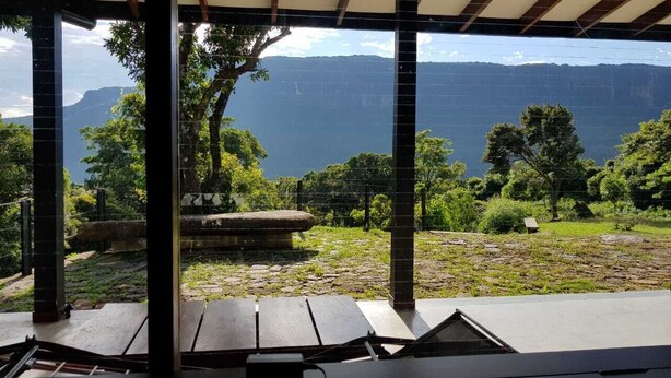 A covered outdoor area with a view of a mountainous landscape and a body of water. - Riverston mountain view bungalow (Matale)