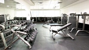 A gym with various exercise equipment, including dumbbells, benches, and weight machines. - DM1 Comfortable Apartment in Dubai Marina (Dubai)