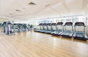 A gym with multiple treadmills, stationary bikes, and other fitness equipment.