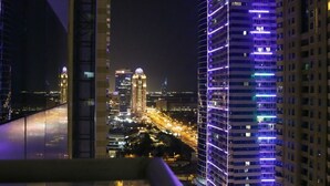 A nighttime cityscape with illuminated skyscrapers and a busy highway. - DM1 Comfortable Apartment in Dubai Marina (Dubai)