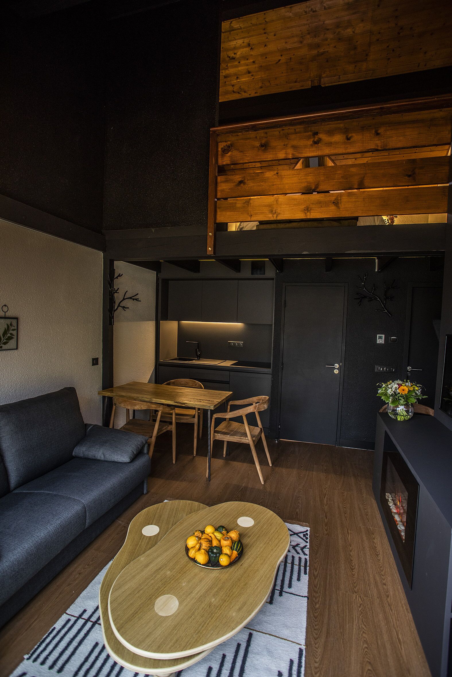 Un espacio habitable moderno con sofá, mesa de comedor y zona de cocina.