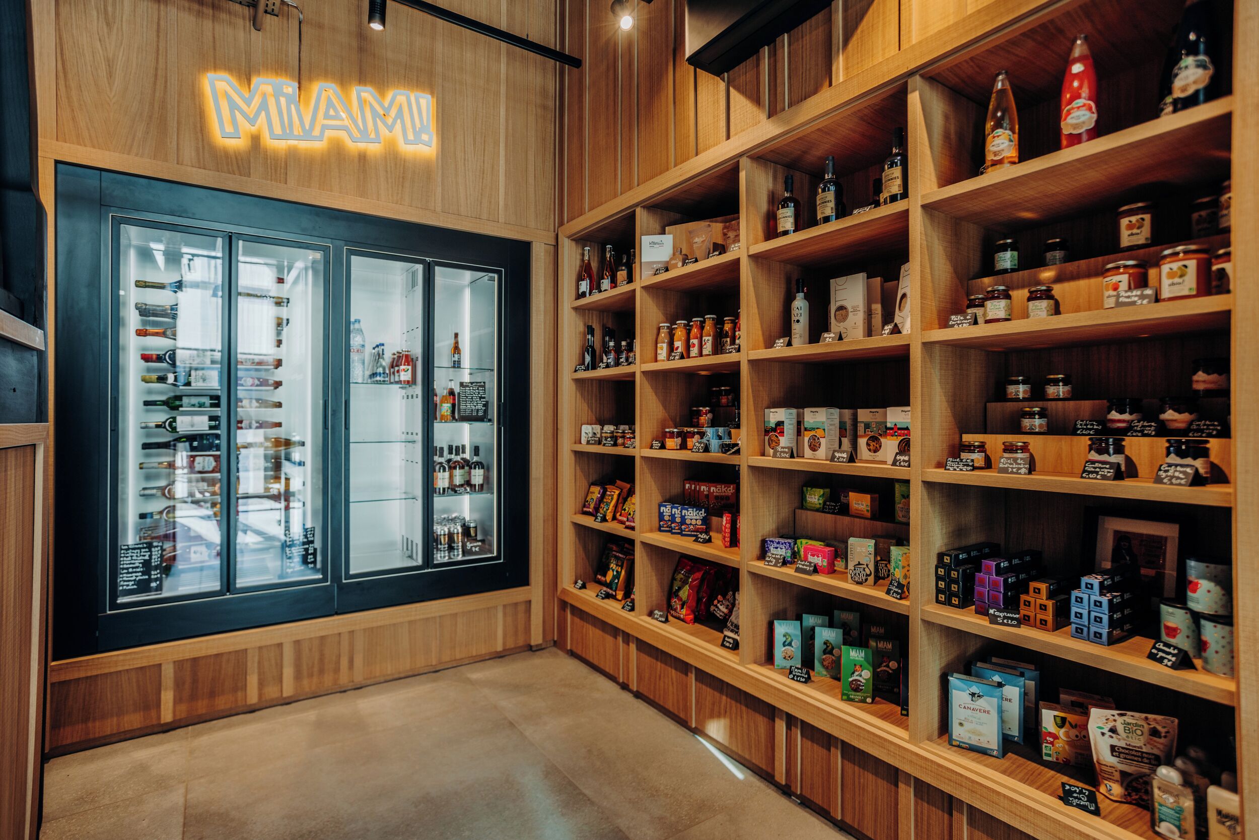 Una tienda con estanterías repletas de productos y un expositor refrigerado.
