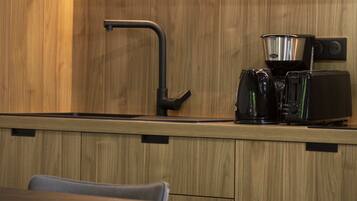 A kitchen with wooden cabinets, a coffee maker, and a toaster.