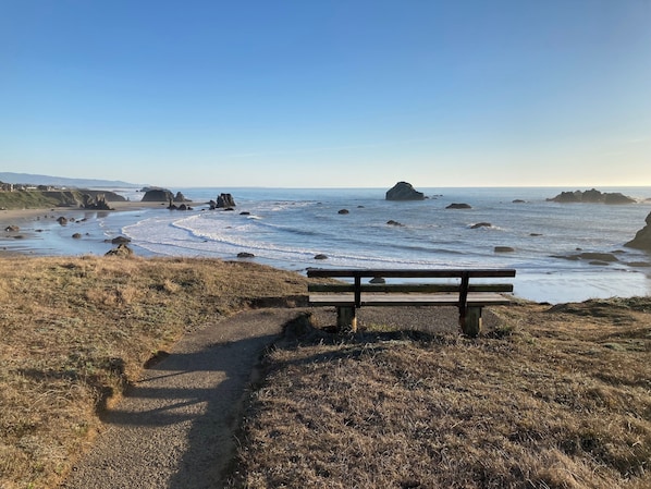 Situated on a grassy path, this bench offers a serene view of the ocean and the surrounding rock formations.