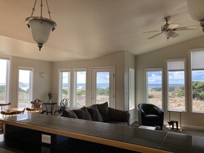 Relax in this stylish living area with expansive ocean views, a large kitchen island, and a high ceiling.