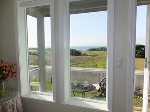 Enjoy a serene view of the grassy landscape and sea from this room's large window.