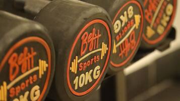 A set of 10KG dumbbells with the brand name 'Beit Sports' on a rack.