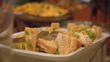 A buffet with various dishes, including a salad and bread.