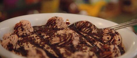 Eine Dessertschale mit Schokoladen- und Sahnelzwirbeln, einem Löffel und unscharfem Hintergrund.