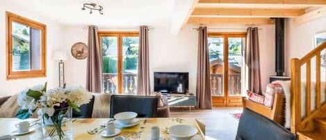 A dining area with a table set for four, a television, and a fireplace.