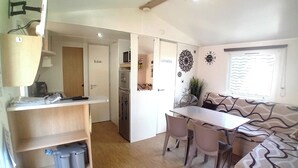 Un espacio habitable compacto con kitchenette, comedor y sofá.