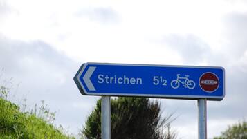 Ein Wegweiser nach Strichen mit Fahrradsymbol und Entfernungsangabe.