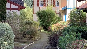 A pathway leading to traditional houses with a mix of architectural styles, surrounded by lush greenery. - 3-room cottage near sea and golf in Moliets (Moliets-et-Maa)