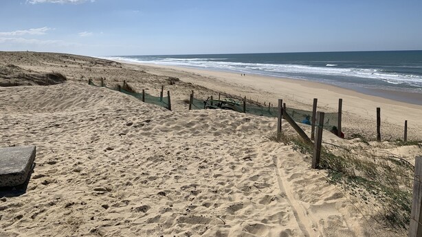 A sandy beach with a wooden fence and a boat. - 3-room cottage near sea and golf in Moliets (Moliets-et-Maa)