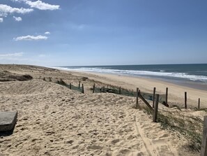 Une plage de sable avec une clôture en bois et un bateau.
