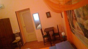 A room with a bed, a desk, and a chair. There is a door and a mirror on the wall. - Palermo Centrale (Palermo)