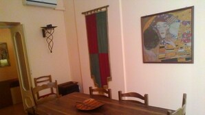 A dining area with a wooden table and chairs, a flag, and a painting on the wall. - Palermo Centrale (Palermo)