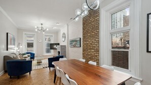 Een moderne woonkamer met een eetgedeelte, een open haard en grote ramen.