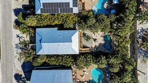 Ein Wohnhaus mit Swimmingpool, Solaranlage und überdachter Terrasse.
