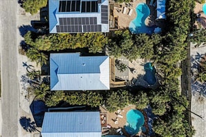 Propiedad residencial con piscina, paneles solares y terraza cubierta.