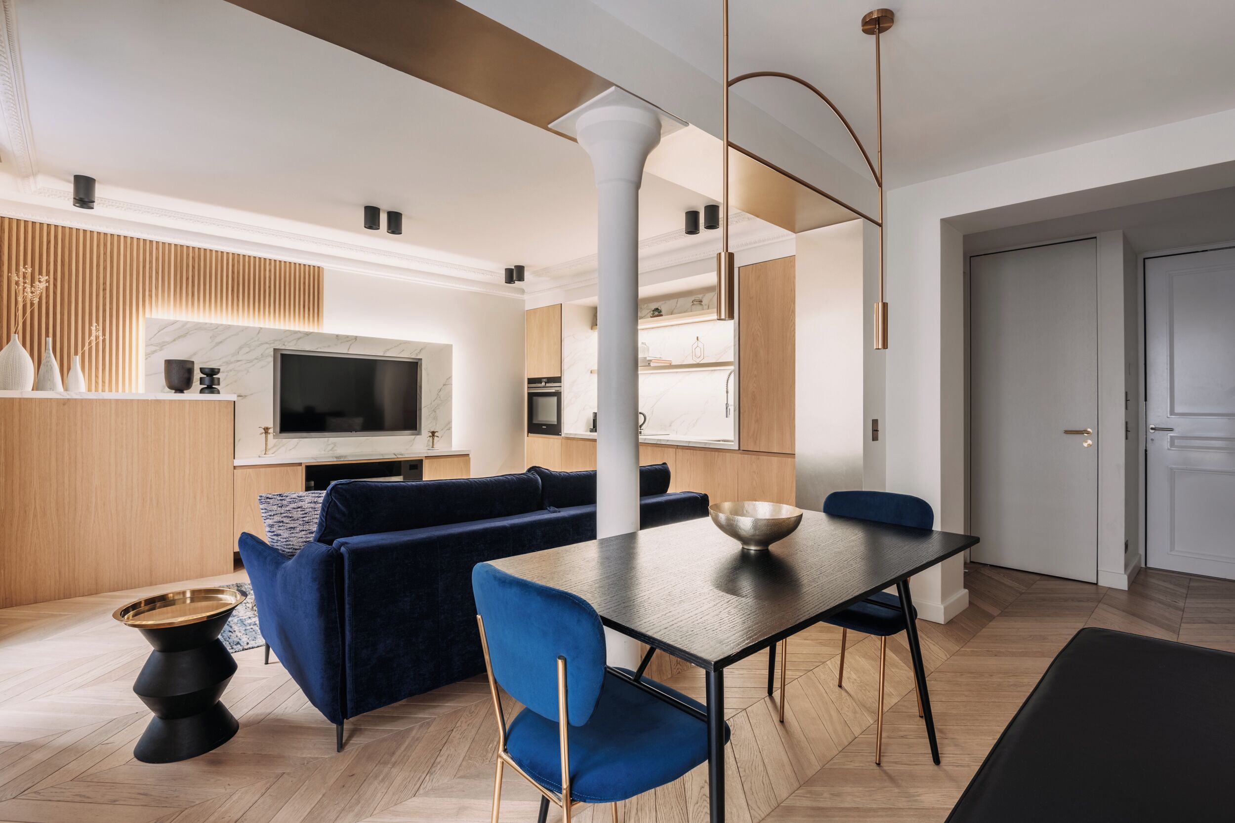 A modern living room with a sofa, dining table, and TV.