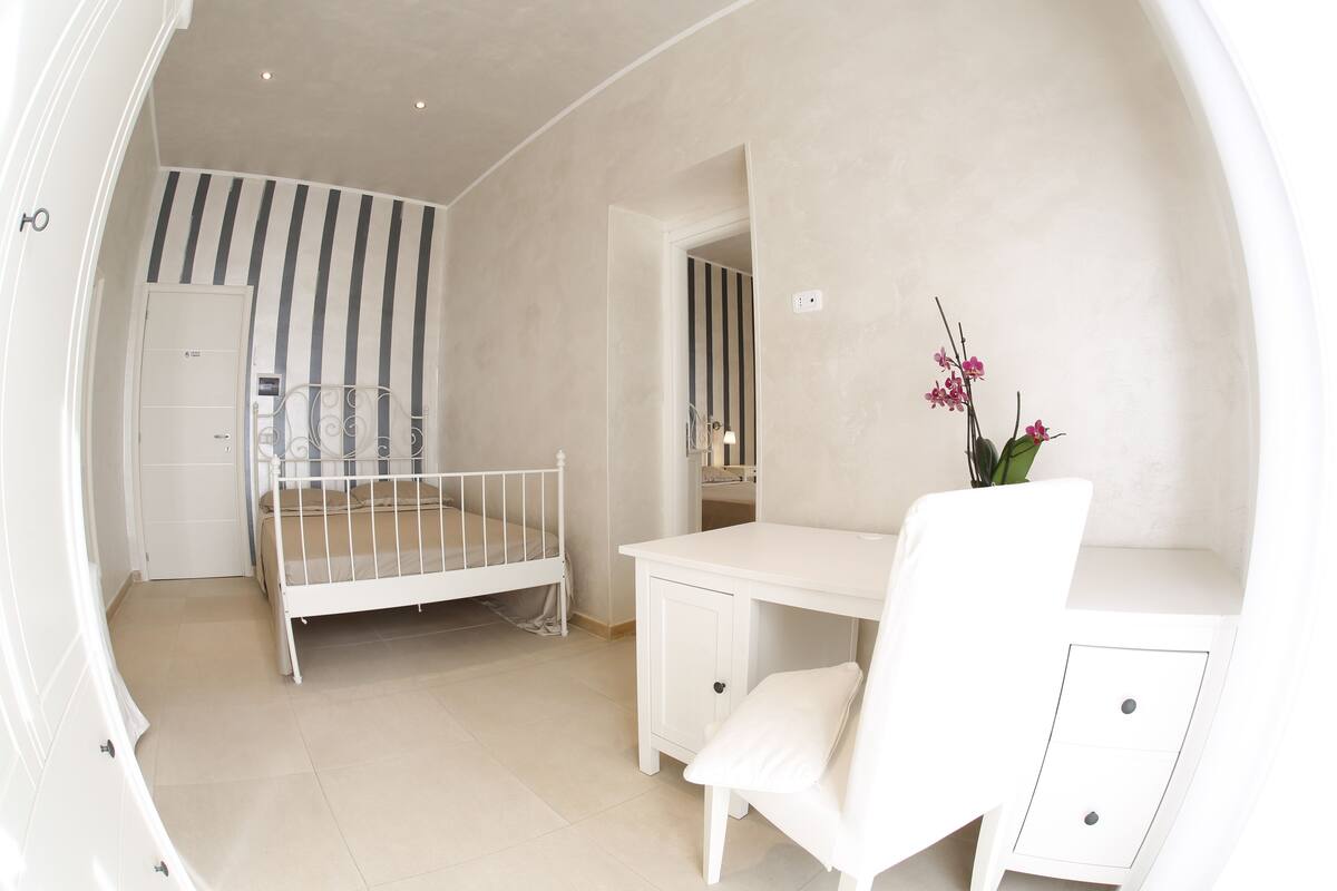 A child's room with a bed, a desk, and a chair.