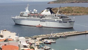 A large cruise ship docked at a port with a marina in the foreground. - Bella Vista Design Studios (Andros)