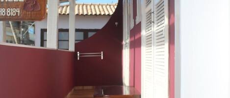 Un corredor cubierto con suelo de madera, un banco y un cartel con el nombre 'VILLE'.