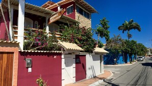 A two-story building with a red facade, a balcony, and a sign that reads "Rouxville". - Pousada Bougainville Suites (Arraial do Cabo)