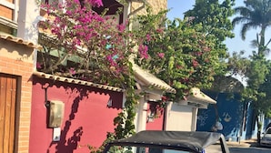 A blue Bugre car parked in front of a building with a sign that reads "Bougainville Suites." - Pousada Bougainville Suites (Arraial do Cabo)