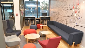 A modern lounge area with a sofa, chairs, and tables. - Holiday Inn Express Sindelfingen by IHG (Sindelfingen)