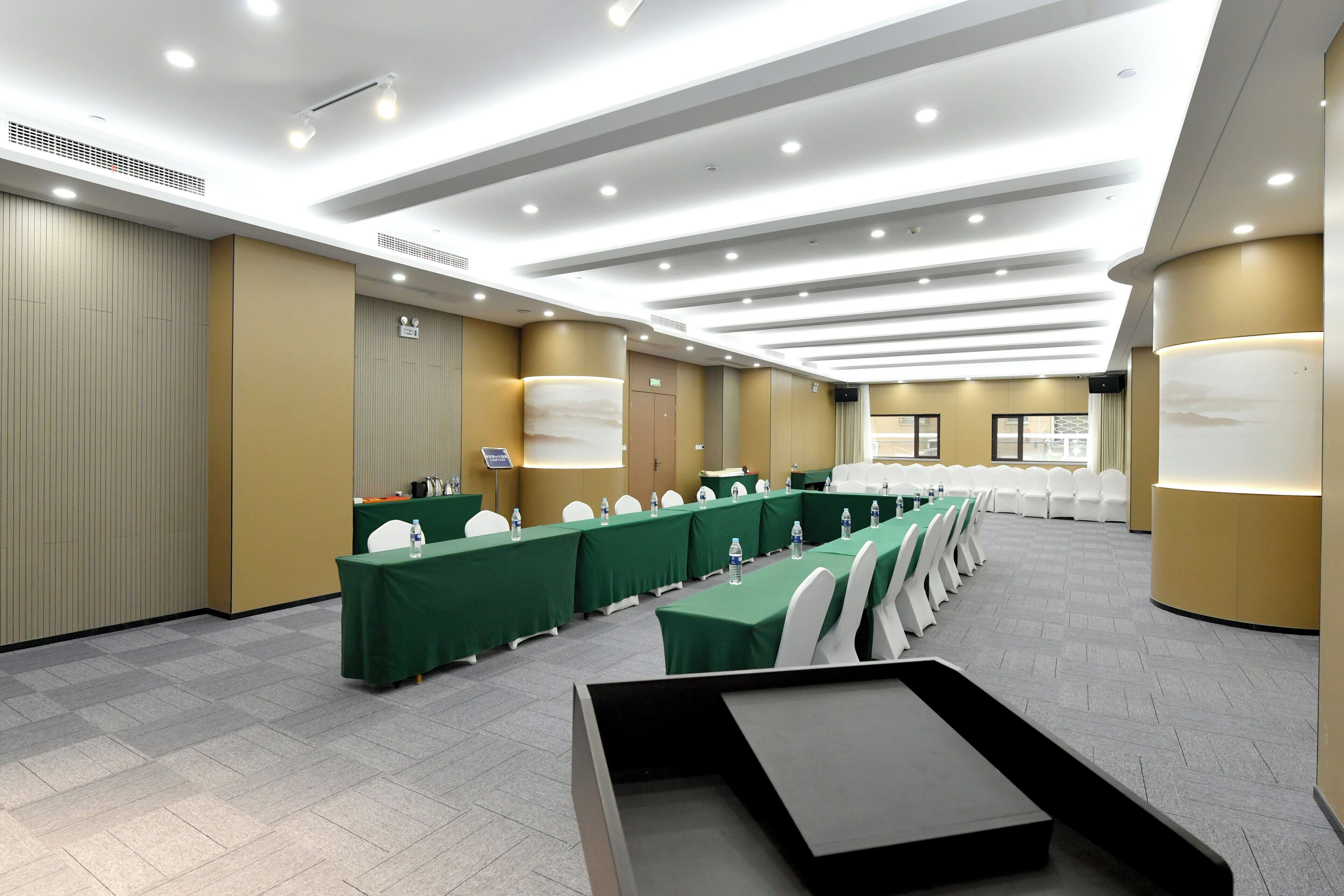 A conference room with a long table, chairs, and a podium.
