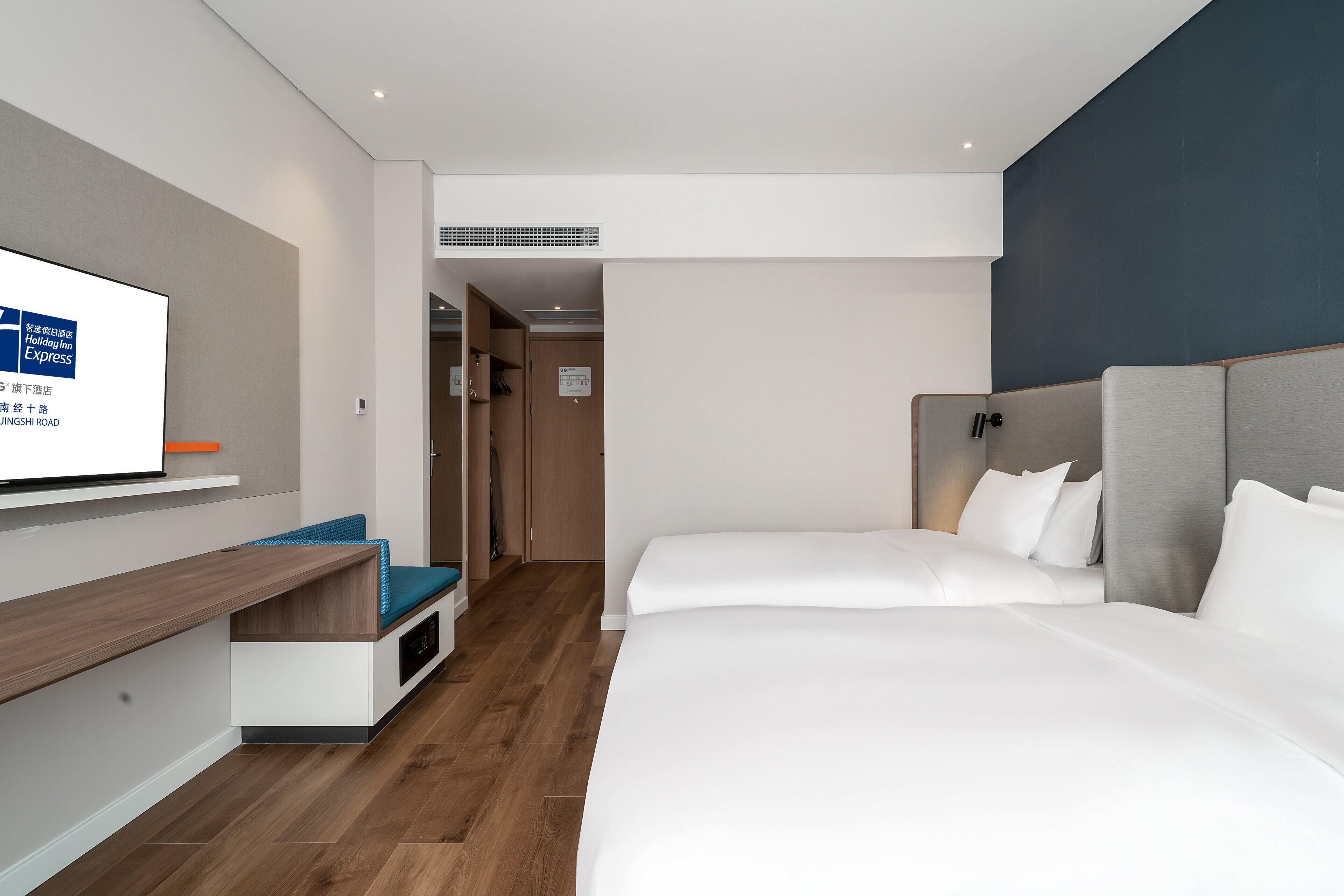 Una habitación de hotel con una cama, un escritorio y un televisor.