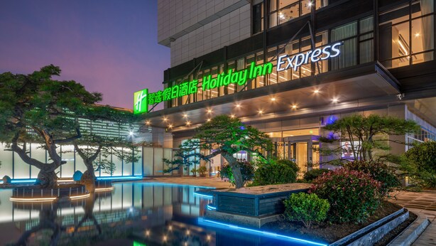 A Holiday Inn Express hotel with a pool area and outdoor seating. - Holiday Inn Express Linyi North New District by IHG (Linyi)