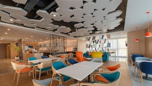 A modern hotel lobby with a central seating area, a bar, and a reception desk. - Holiday Inn Express Linyi North New District by IHG (Linyi)