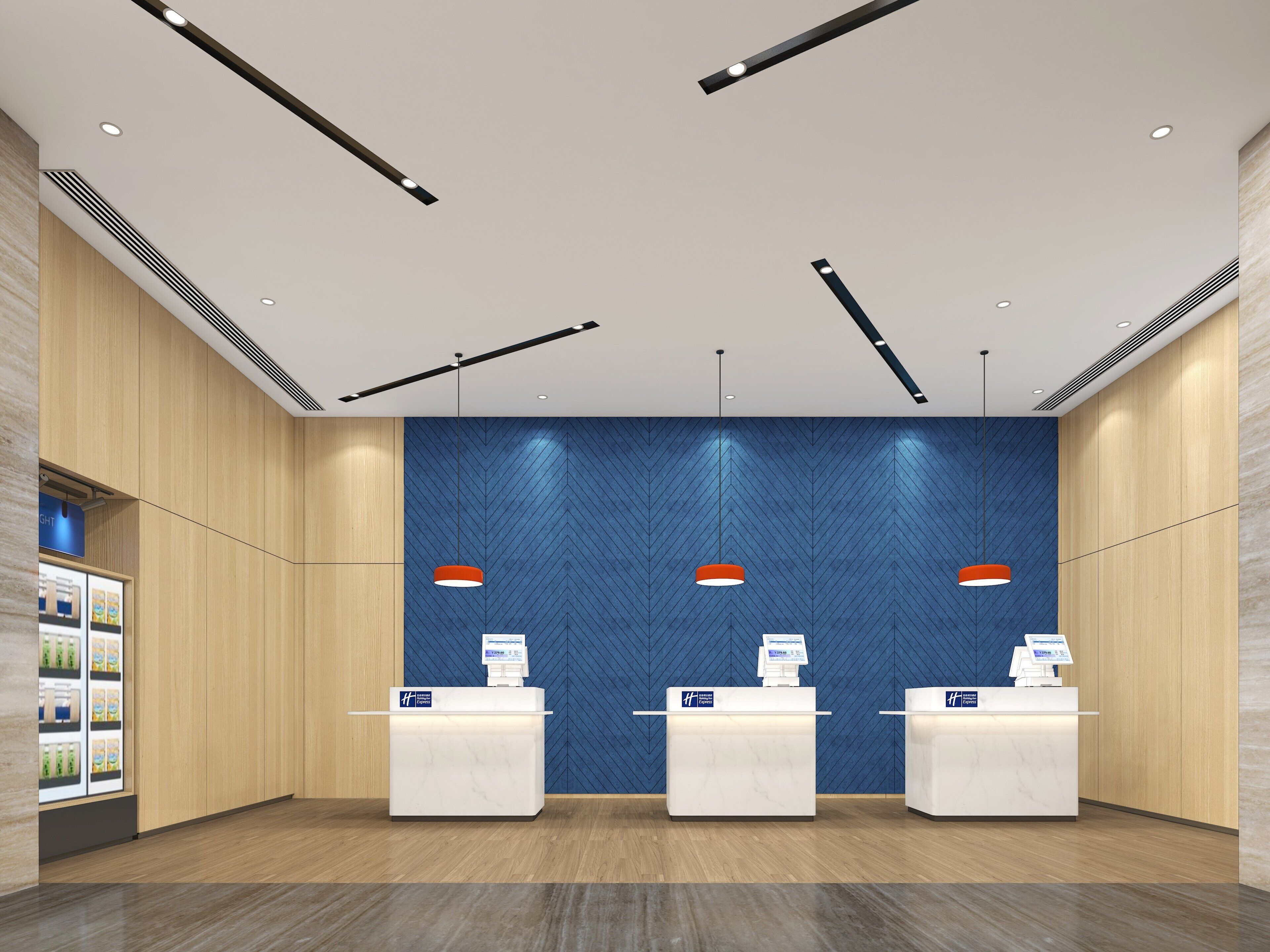 A reception area with three white reception desks, a blue herringbone-patterned wall, and a wooden floor.
