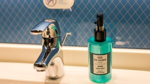 Un lavamanos de baño con un grifo moderno y una botella de jabón líquido Ben Sherman Original.