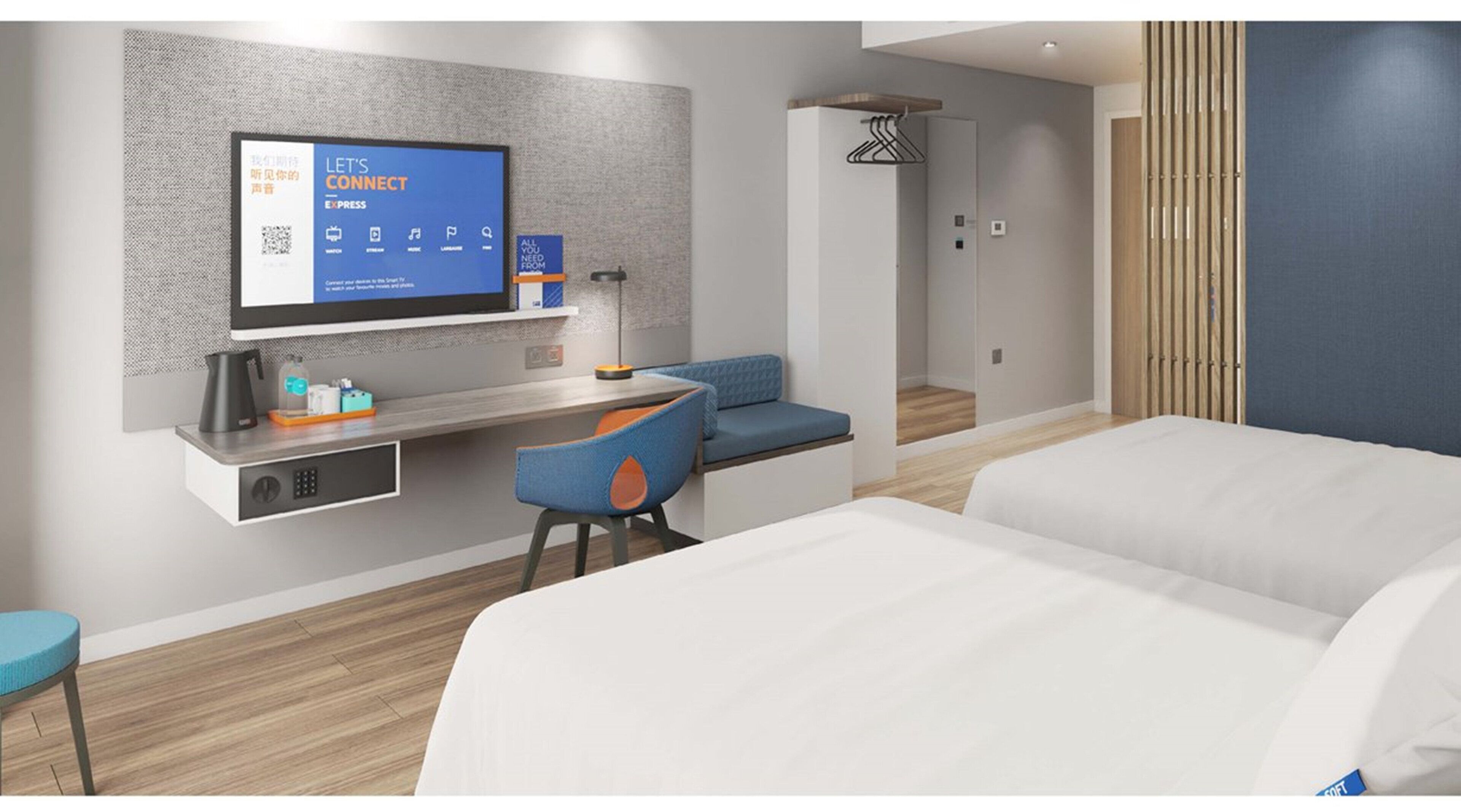 A modern hotel room with a flat-screen TV mounted on the wall, a desk with a chair, a sofa, and a bed.
