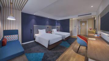Une chambre d’hôtel avec deux lits, un canapé, un bureau et une télévision.