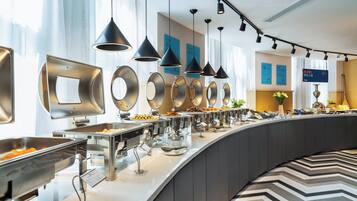 Een buffetgedeelte met verschillende food stations, verlichtingsarmaturen en een modern interieur.