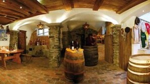 A rustic interior with stone walls, wooden beams, and barrels. - Kaiserpension Müllnerhof (Oberndorf in Tirol)