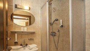 A bathroom with a sink, mirror, shower, and toilet. - Kaiserpension Müllnerhof (Oberndorf in Tirol)