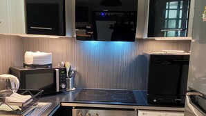 A modern kitchen with a microwave, stove, dishwasher, and washing machine. - Montmartre Moulin rouge Batignolles (Paris)