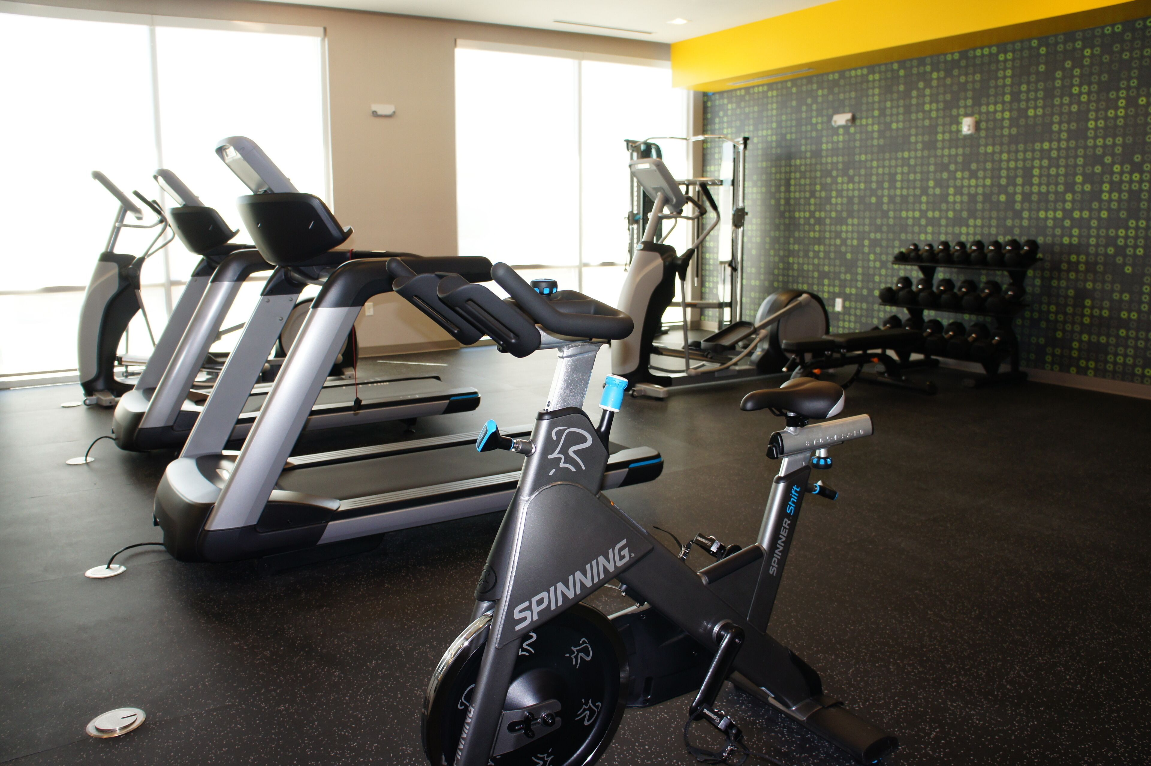 A gym with stationary bikes, treadmills, and weight machines.